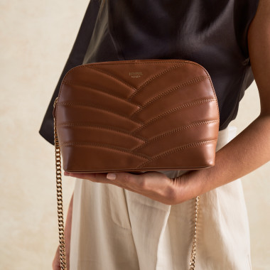 Tan quilted leather bag with a gold chain, next to soaps - MONPIEL 2