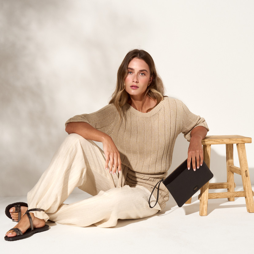 Sandali infradito a listini Siena color piombo, donna seduta a terra, figura intera - MONPIEL