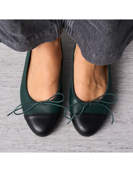 Green leather flat ballet shoe with black toe cap, top view of feet together on the floor - MONPIEL
